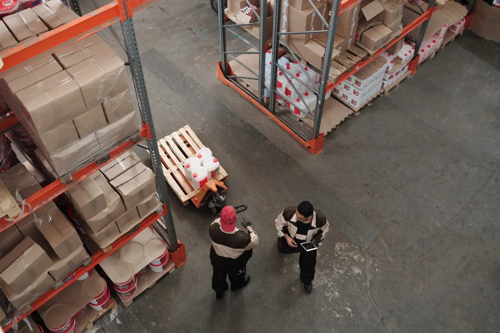 Licensed stock photograph of warehouse workers organizing goods among pallets and shelving